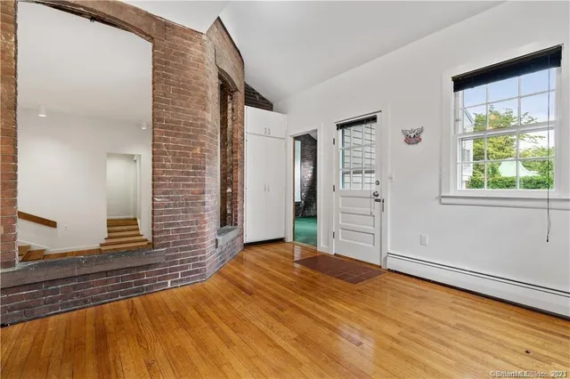 a view of a livingroom with wooden floor and windows