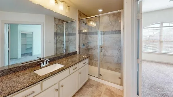 a bathroom with a granite countertop sink mirror and shower