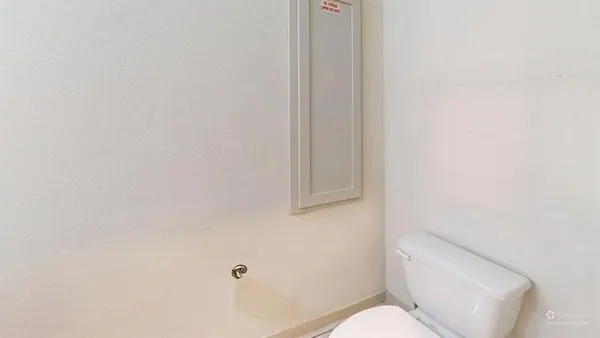 a white toilet sitting next to a shower