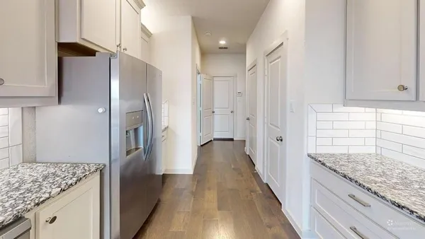 a kitchen with stainless steel appliances granite countertop a refrigerator and a sink