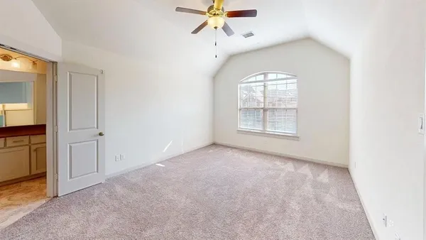 an empty room with windows and fan