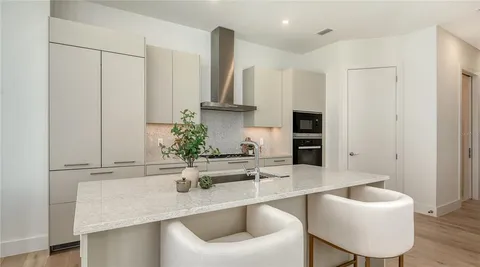 a kitchen with stainless steel appliances granite countertop a sink refrigerator and cabinets