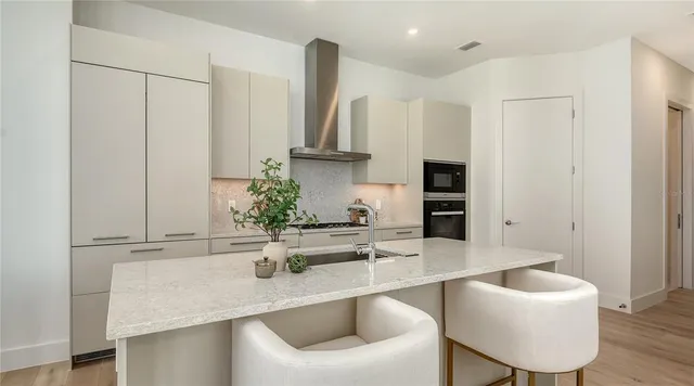 a kitchen with stainless steel appliances granite countertop a sink refrigerator and cabinets