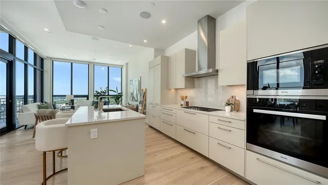 a large kitchen with stainless steel appliances lots of counter space and a sink