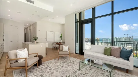 a living room with furniture wooden floor and a large window