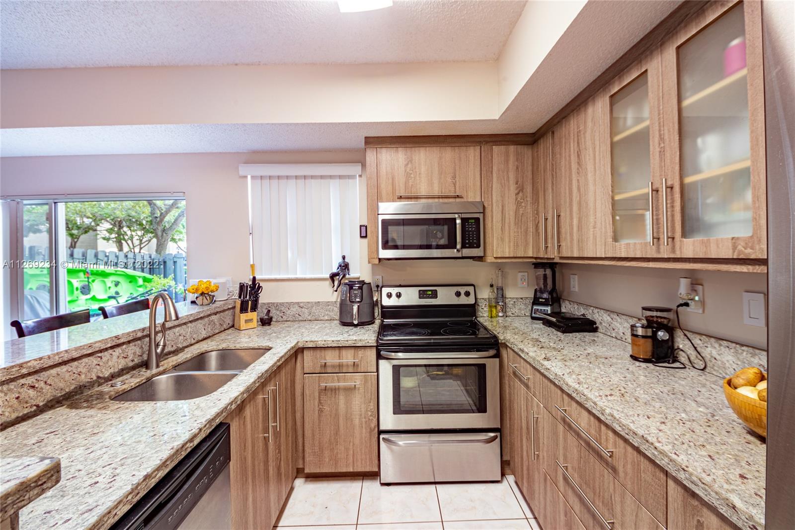 Doral Doral, FL 33178 - Photo 13 of 25 a kitchen with granite countertop a stove sink and microwave