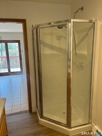 a bathroom with a glass door shower and a mirror