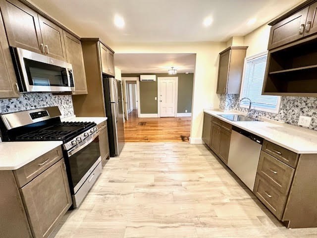 37 Gordon Street, Unit 1 Waltham, MA 02453 - Photo 4 of 12 a large kitchen with stainless steel appliances a stove a sink and a microwave