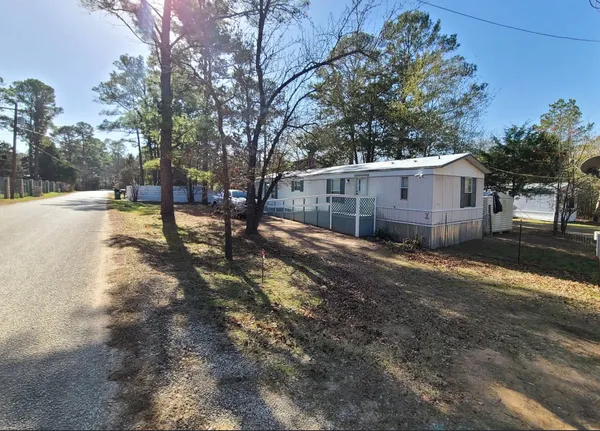 a view of a house with backyard and trees