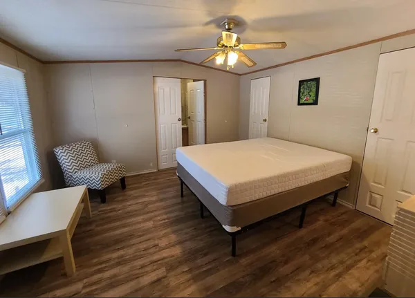 a living room with furniture a window a sink and a flat screen tv