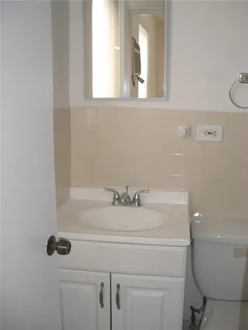 a bathroom with a sink a toilet and a mirror
