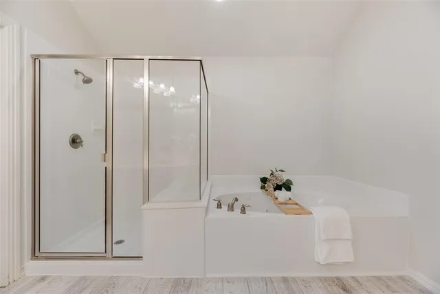 an empty room with chandelier fan and windows