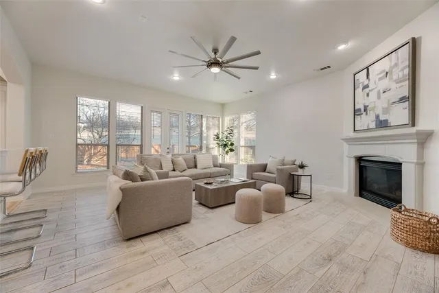 a living room with furniture a fireplace and a large window