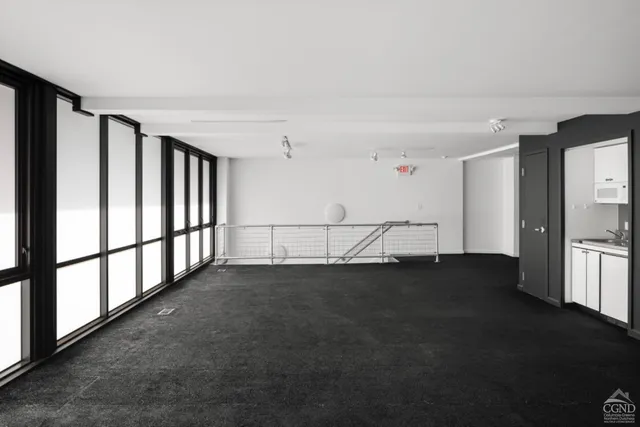 a view of an empty room with chandelier fan and wooden floor