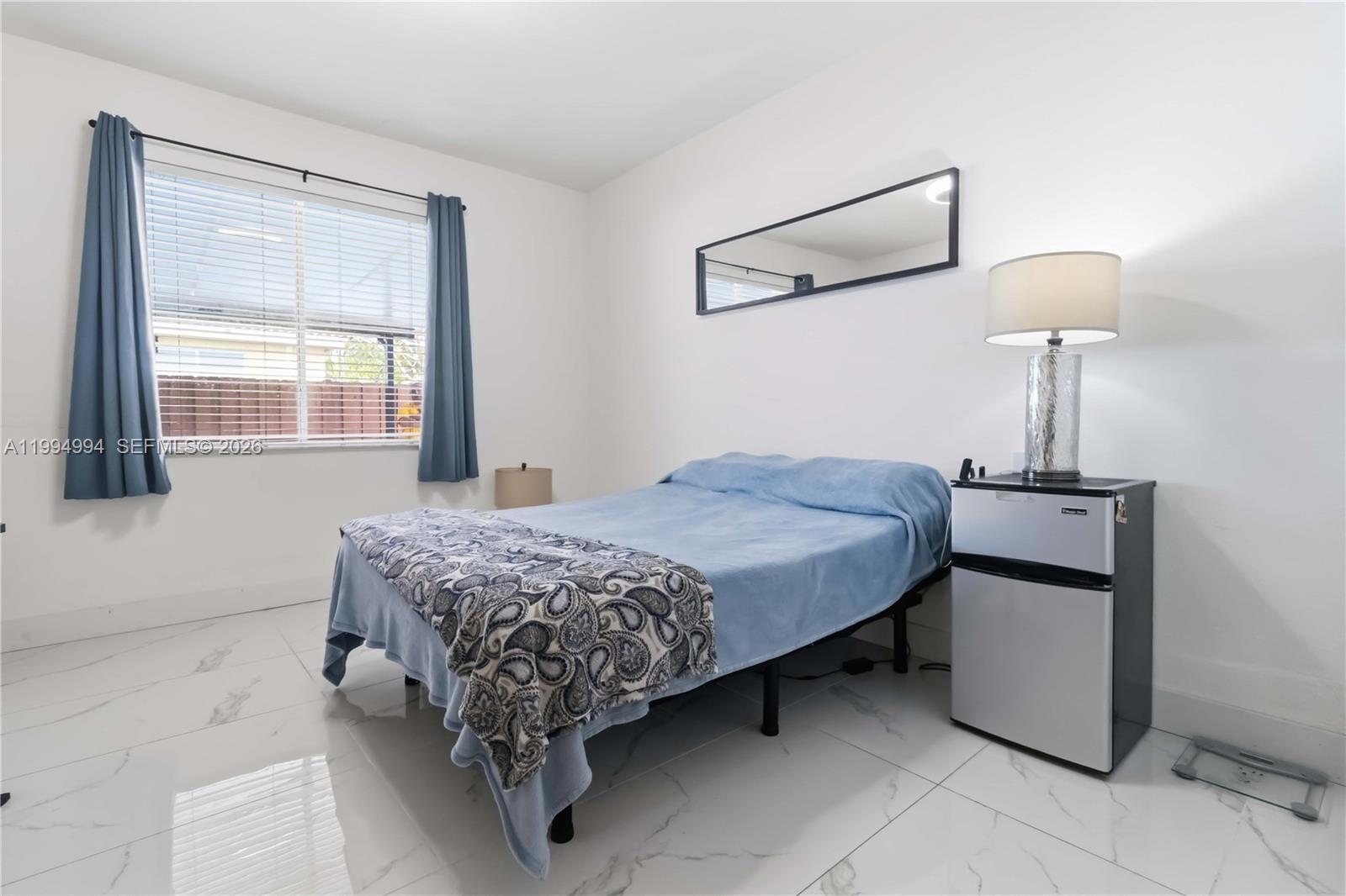 64 Southwest 15th Terrace Homestead, FL 33030 - Photo 13 of 26 a bedroom with a bed and a lamp