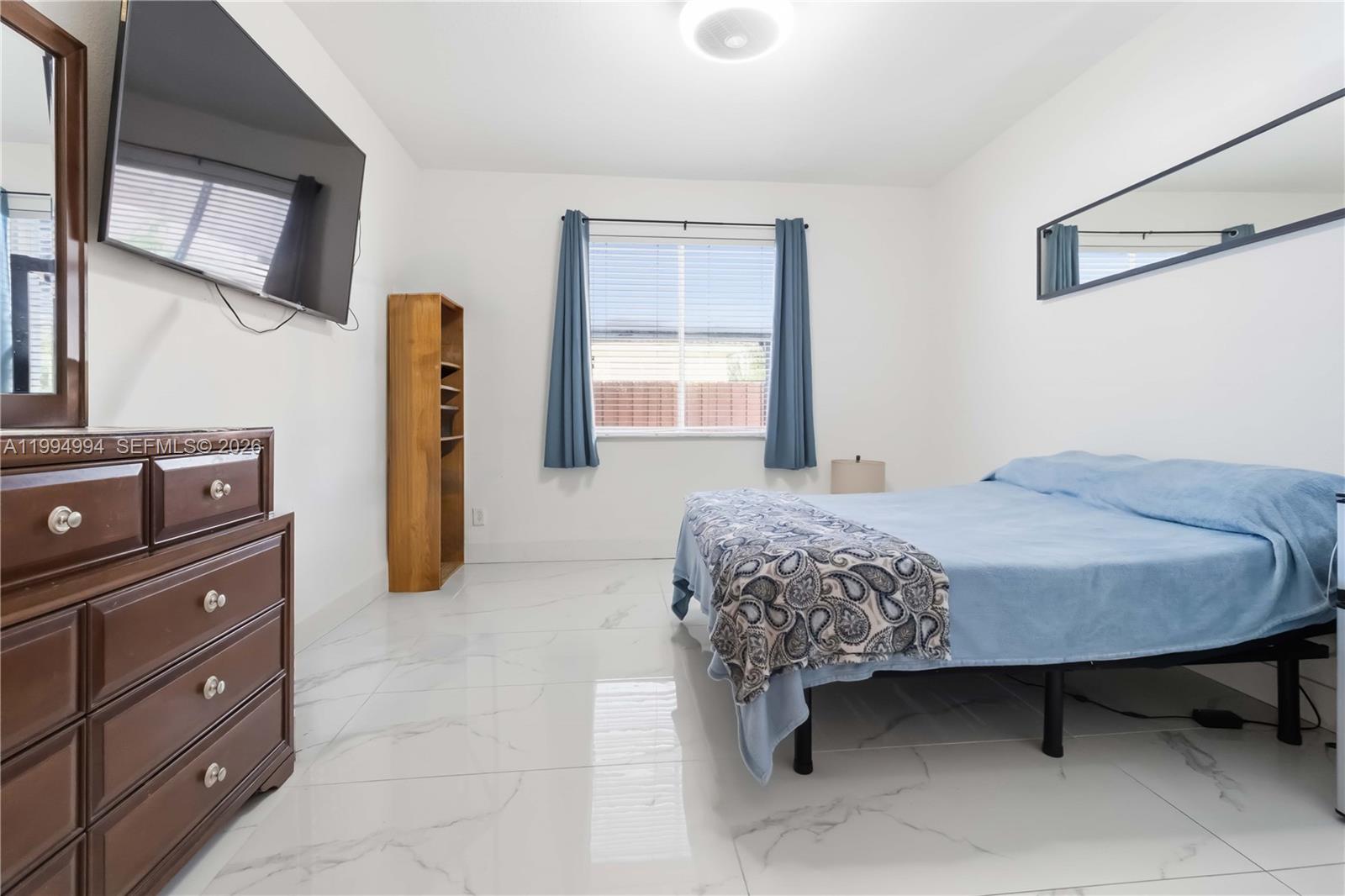 64 Southwest 15th Terrace Homestead, FL 33030 - Photo 14 of 26 a bedroom with a bed and a dresser