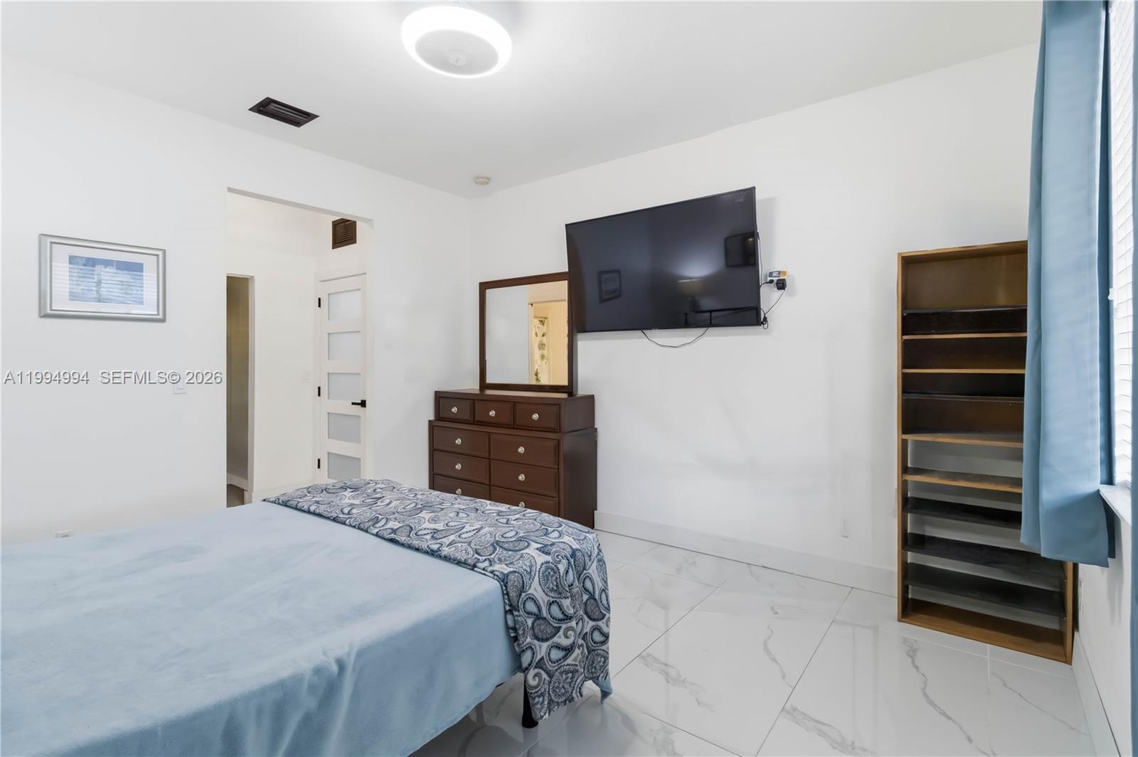 64 Southwest 15th Terrace Homestead, FL 33030 - Photo 15 of 26 a bedroom with a bed and a flat screen tv