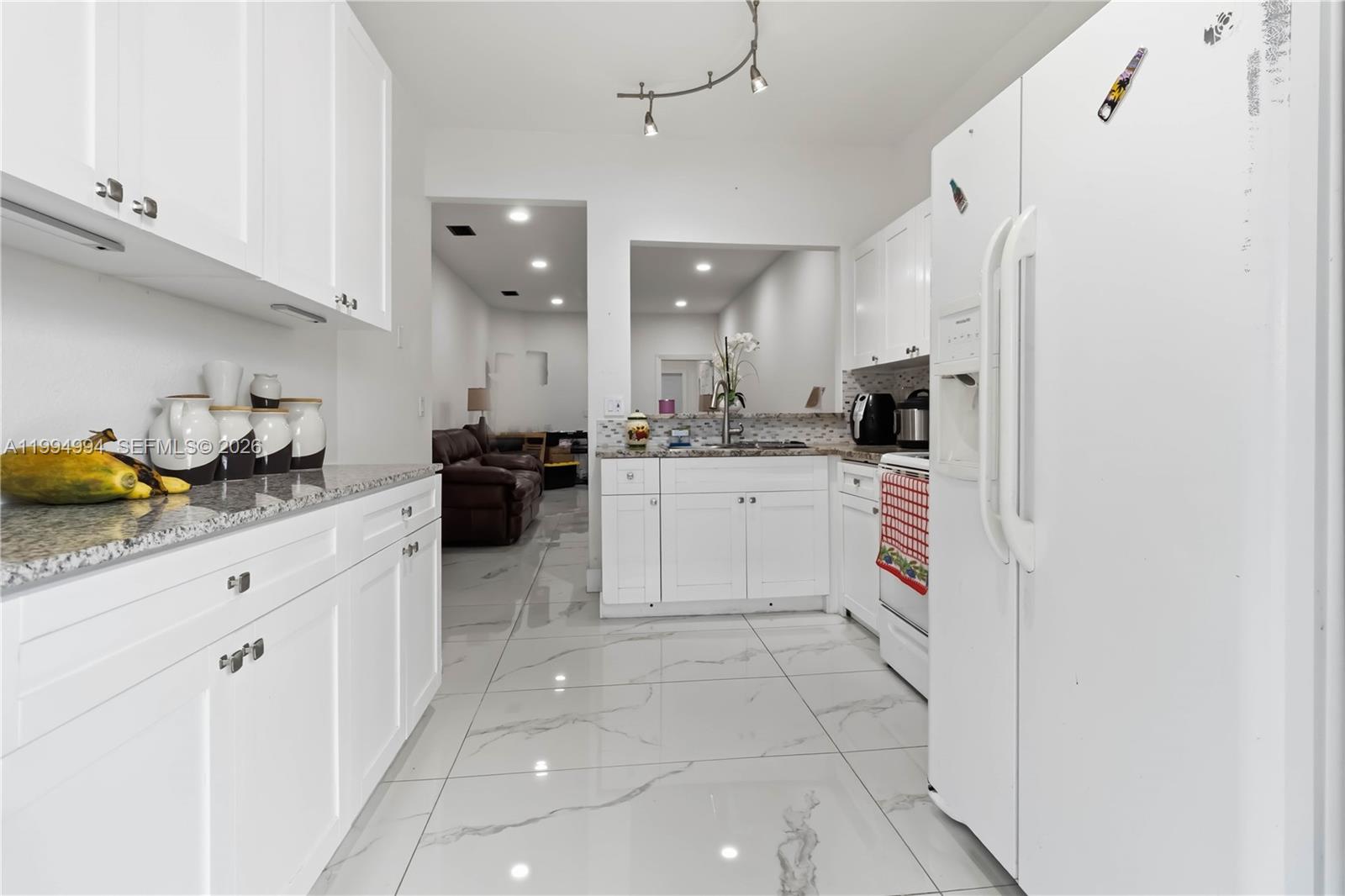 64 Southwest 15th Terrace Homestead, FL 33030 - Photo 3 of 26 a kitchen with stainless steel appliances granite countertop a sink and cabinets