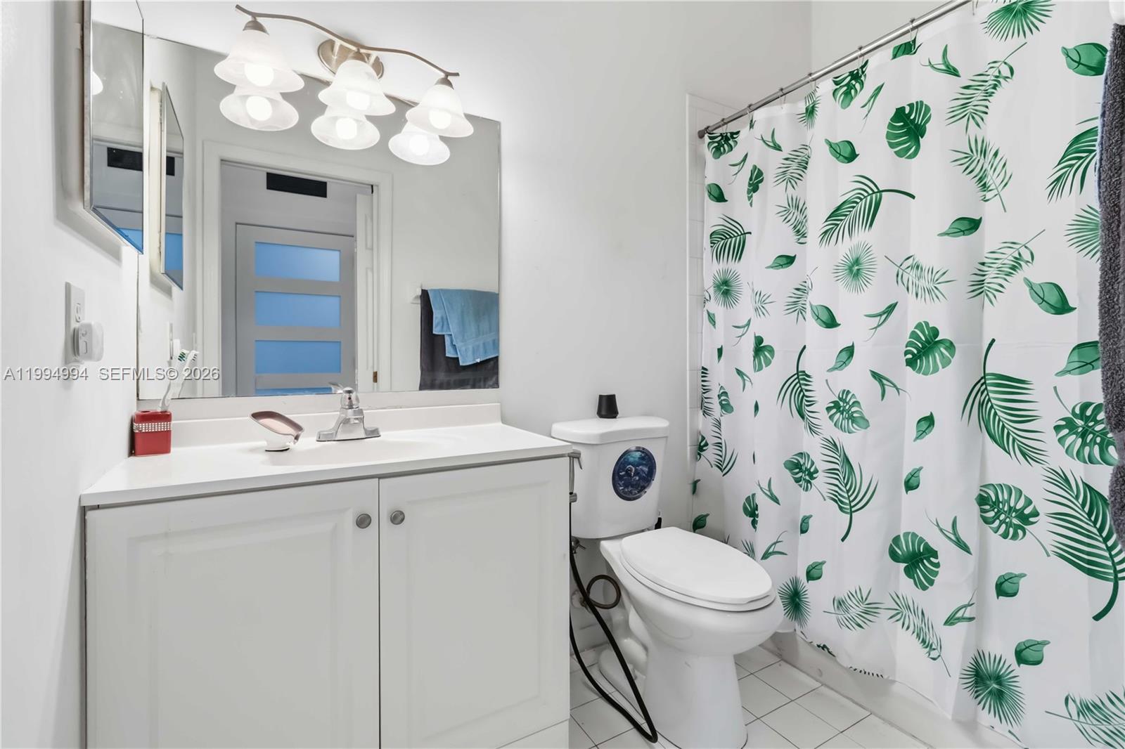 64 Southwest 15th Terrace Homestead, FL 33030 - Photo 4 of 26 a bathroom with a sink a toilet and shower curtain