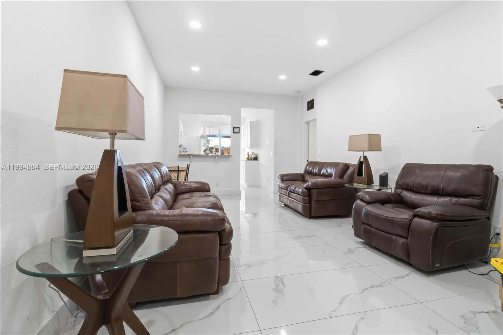64 Southwest 15th Terrace Homestead, FL 33030 - Photo 8 of 26 a living room with furniture a lamp and a flat screen tv