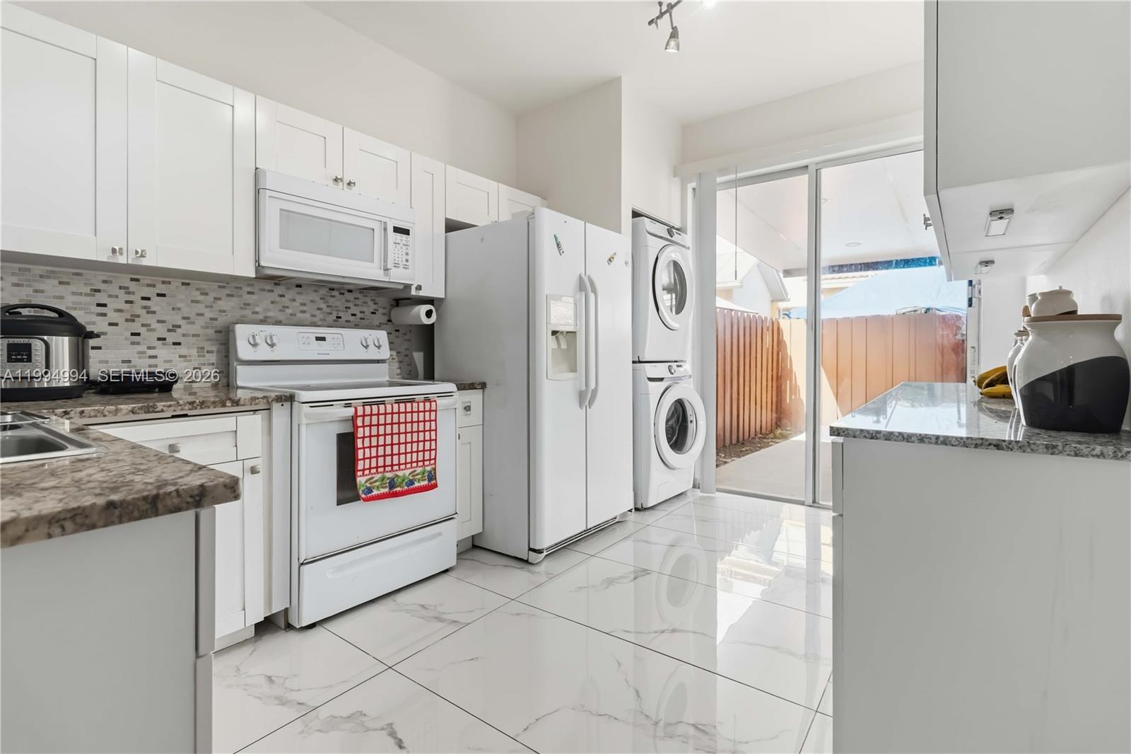 64 Southwest 15th Terrace Homestead, FL 33030 - Photo 9 of 26 a kitchen with stainless steel appliances granite countertop a refrigerator and a stove