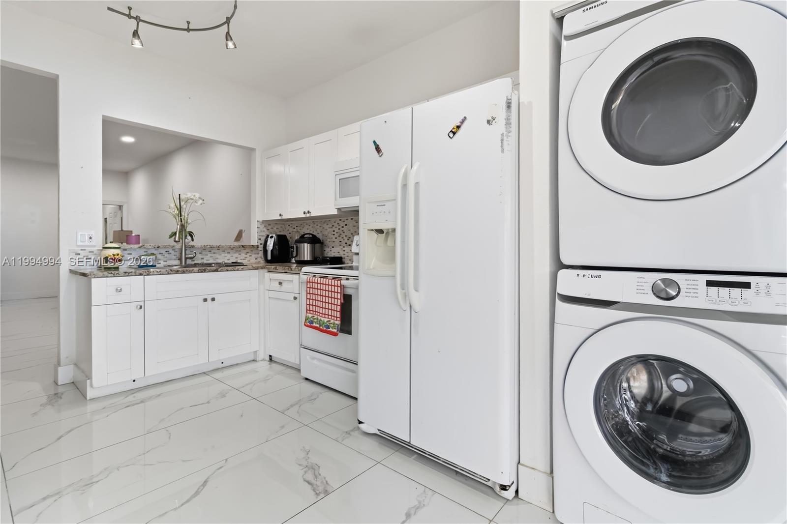 64 Southwest 15th Terrace Homestead, FL 33030 - Photo 10 of 26 a kitchen with a sink a washer and dryer