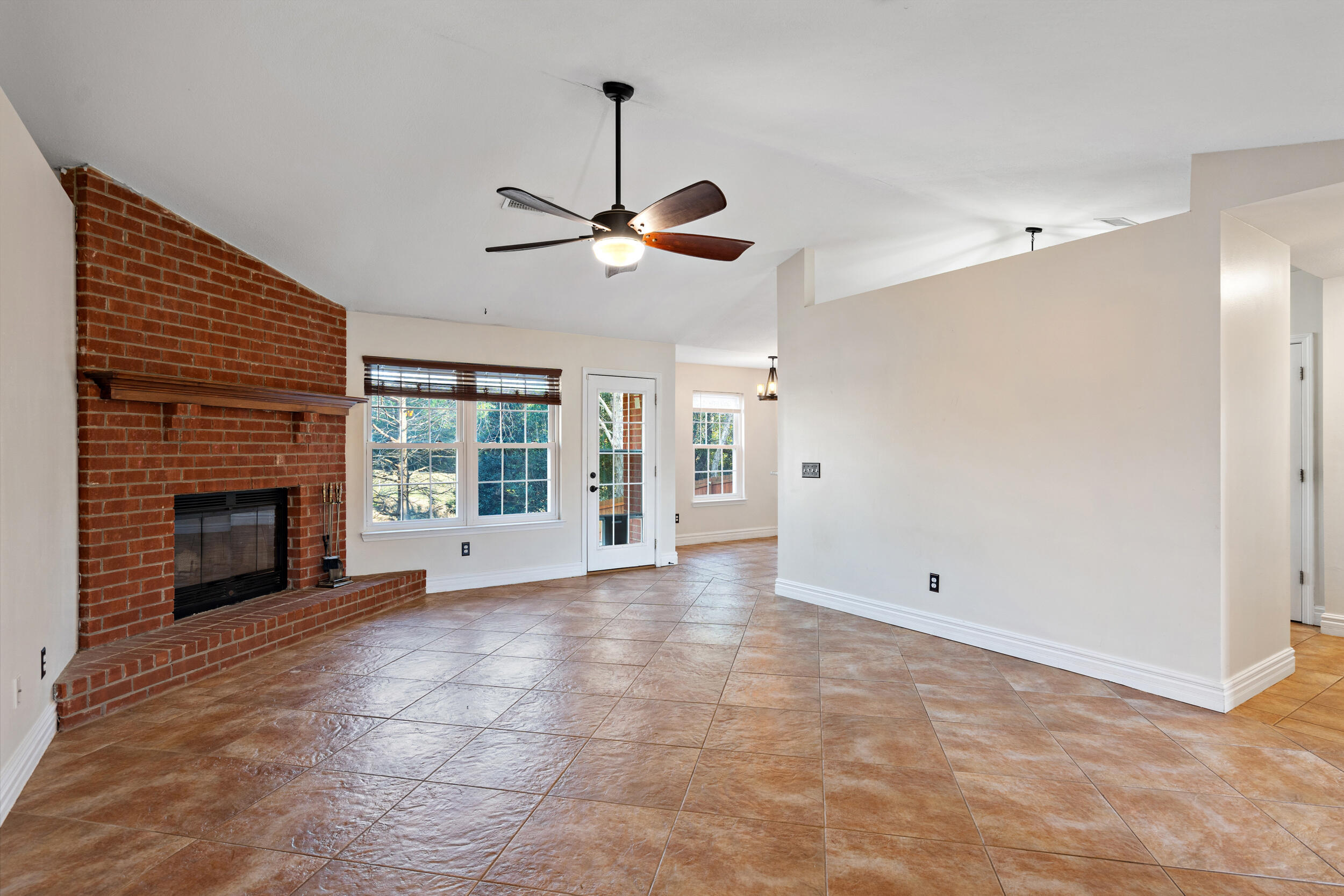 a view of an empty room with a fireplace and a window