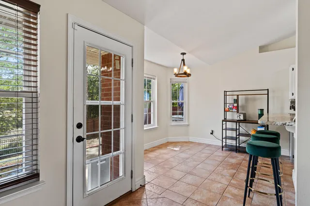 a spacious bedroom with a bed a chandelier and a window