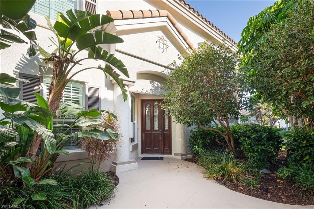 142 Colonade Circle Naples, FL 34103 - Photo 20 of 30 a view of a house with a flower garden