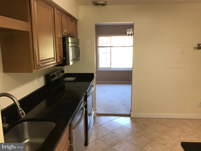 a kitchen with a refrigerator and a stove top oven