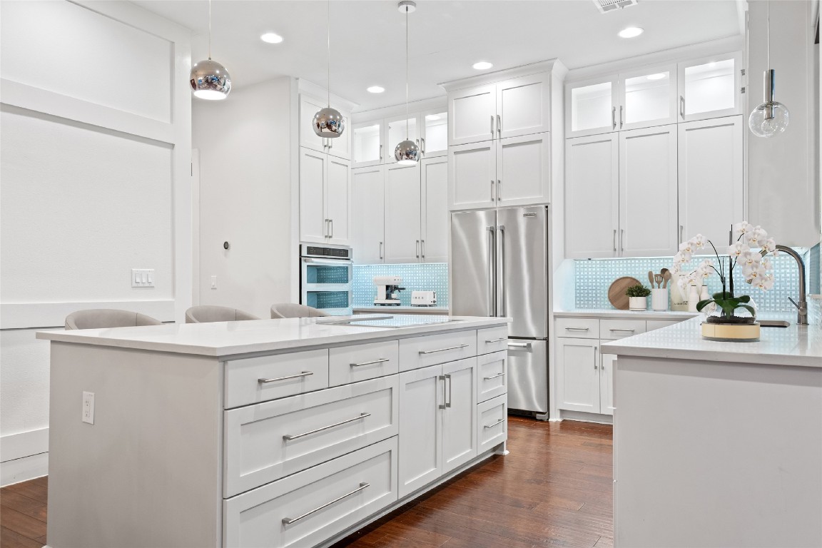 2811 Del Curto Road, Unit A Austin, TX 78704 - Photo 11 of 40 Kitchen featuring glass insert cabinets, stainless steel appliances, tasteful backsplash, decorative light fixtures, and recessed lighting