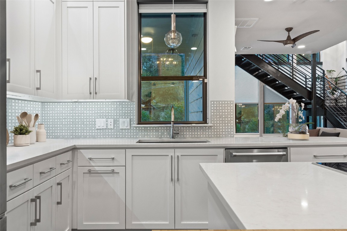 2811 Del Curto Road, Unit A Austin, TX 78704 - Photo 14 of 40 Kitchen featuring white cabinetry, a ceiling fan, light stone countertops, dishwasher, and backsplash