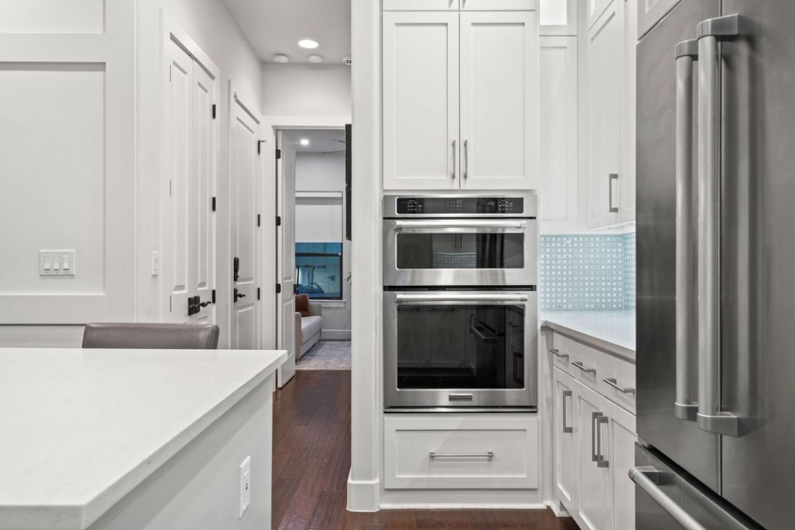 2811 Del Curto Road, Unit A Austin, TX 78704 - Photo 15 of 40 Kitchen with stainless steel appliances, white cabinetry, dark wood-type flooring, light stone countertops, and recessed lighting