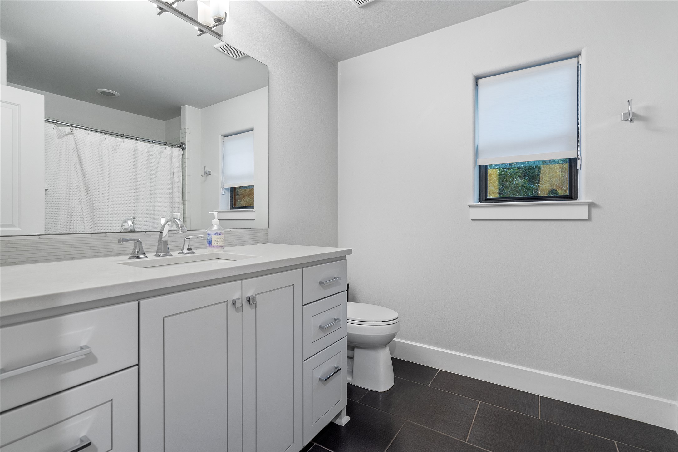 2811 Del Curto Road, Unit A Austin, TX 78704 - Photo 20 of 40 a bathroom with a sink a toilet and mirror