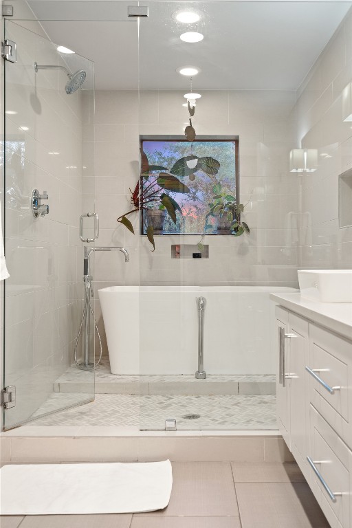 2811 Del Curto Road, Unit A Austin, TX 78704 - Photo 23 of 40 Primary bath featuring vanity, light tile patterned floors, a stall shower, and a soaking tub