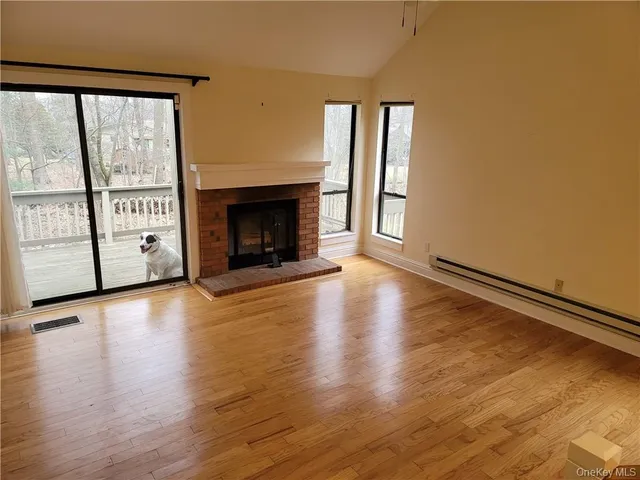 wooden floor fireplace and windows in an empty room