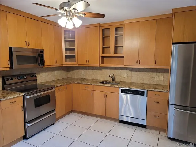 a kitchen with stainless steel appliances granite countertop a refrigerator sink and stove