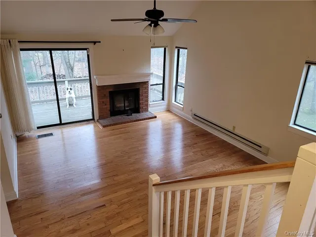 a view of a livingroom with wooden floor and a fireplace