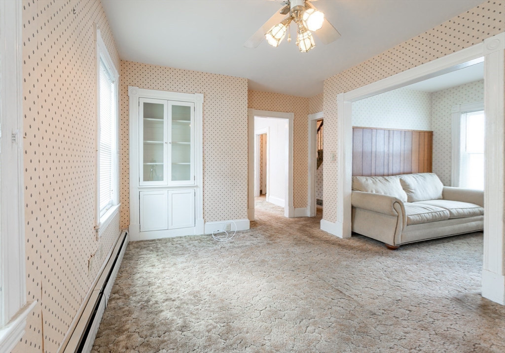 86 Epping Street Lowell, MA 01852 - Photo 12 of 41 a spacious bedroom with a white bed and a chandelier
