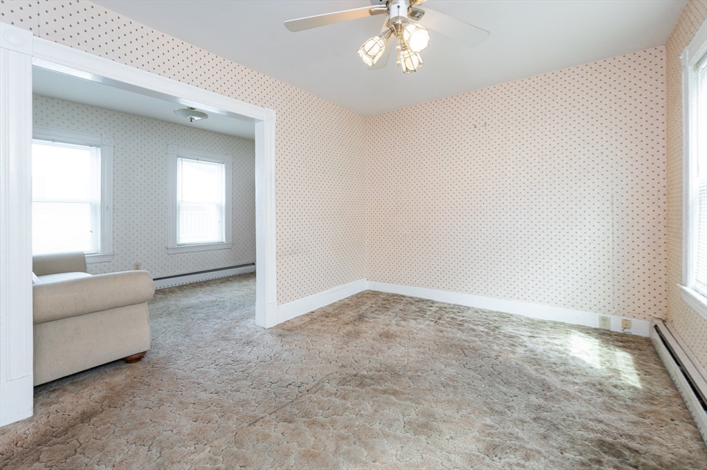 86 Epping Street Lowell, MA 01852 - Photo 13 of 41 an empty room with windows and chandelier fan