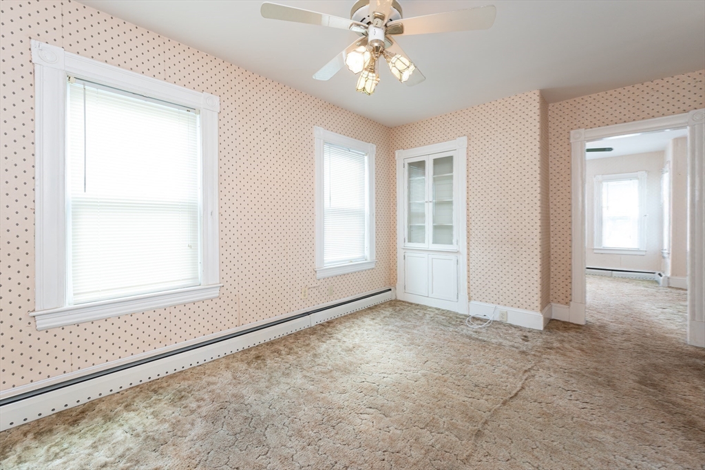 86 Epping Street Lowell, MA 01852 - Photo 15 of 41 an empty room with chandelier fan and windows