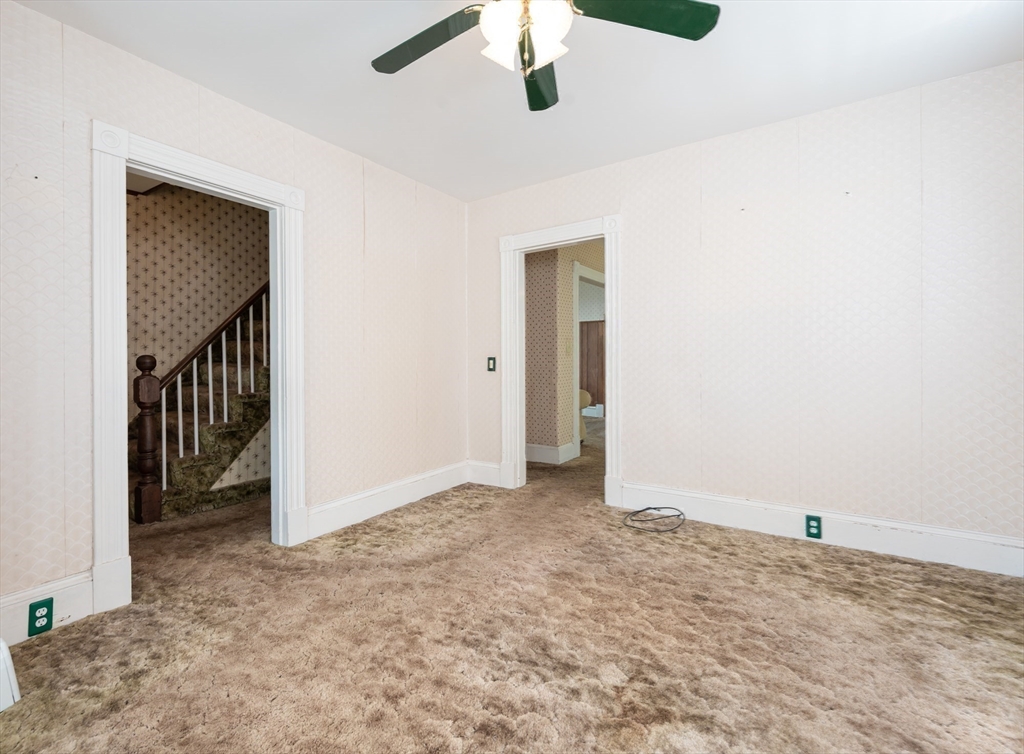 86 Epping Street Lowell, MA 01852 - Photo 17 of 41 an empty room with a ceiling fan and carpet
