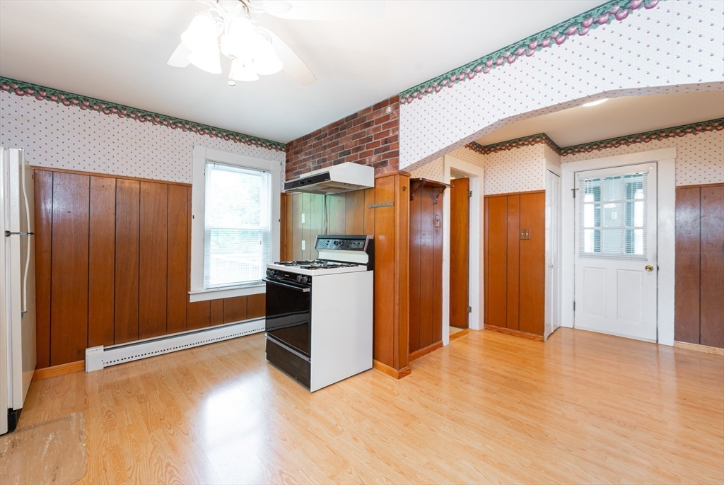 86 Epping Street Lowell, MA 01852 - Photo 2 of 41 a view of a big room with wooden floor and kitchen
