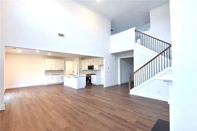 a view of a living room with kitchen and wooden floor
