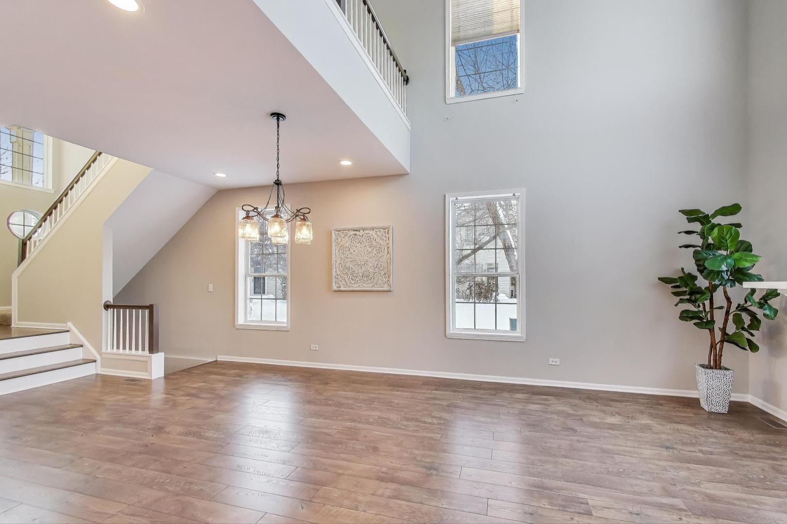 2304 Stonegate Road Algonquin, IL 60102 - Photo 11 of 42 a view of an empty room with wooden floor and a window