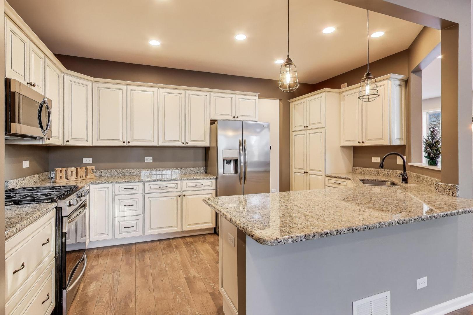 2304 Stonegate Road Algonquin, IL 60102 - Photo 13 of 42 a kitchen with stainless steel appliances granite countertop a sink stove and refrigerator