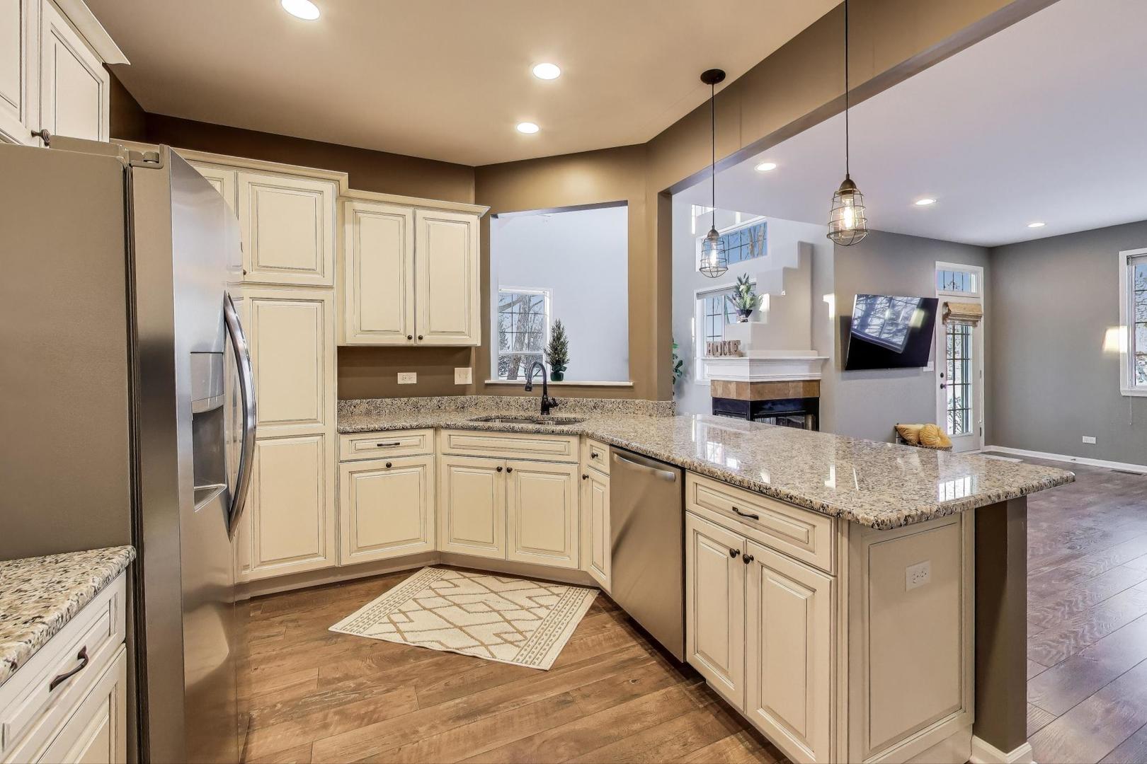 2304 Stonegate Road Algonquin, IL 60102 - Photo 14 of 42 a kitchen with stainless steel appliances granite countertop a sink stove and refrigerator