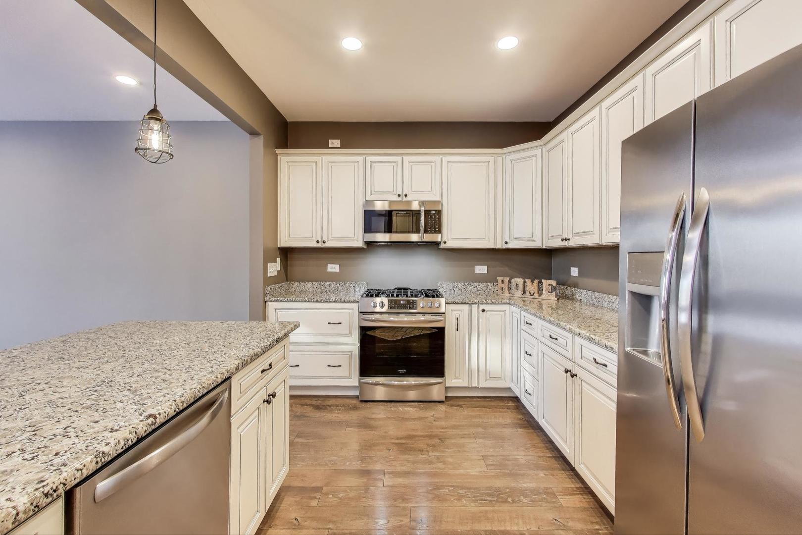 2304 Stonegate Road Algonquin, IL 60102 - Photo 15 of 42 a kitchen with stainless steel appliances granite countertop a stove sink and cabinets