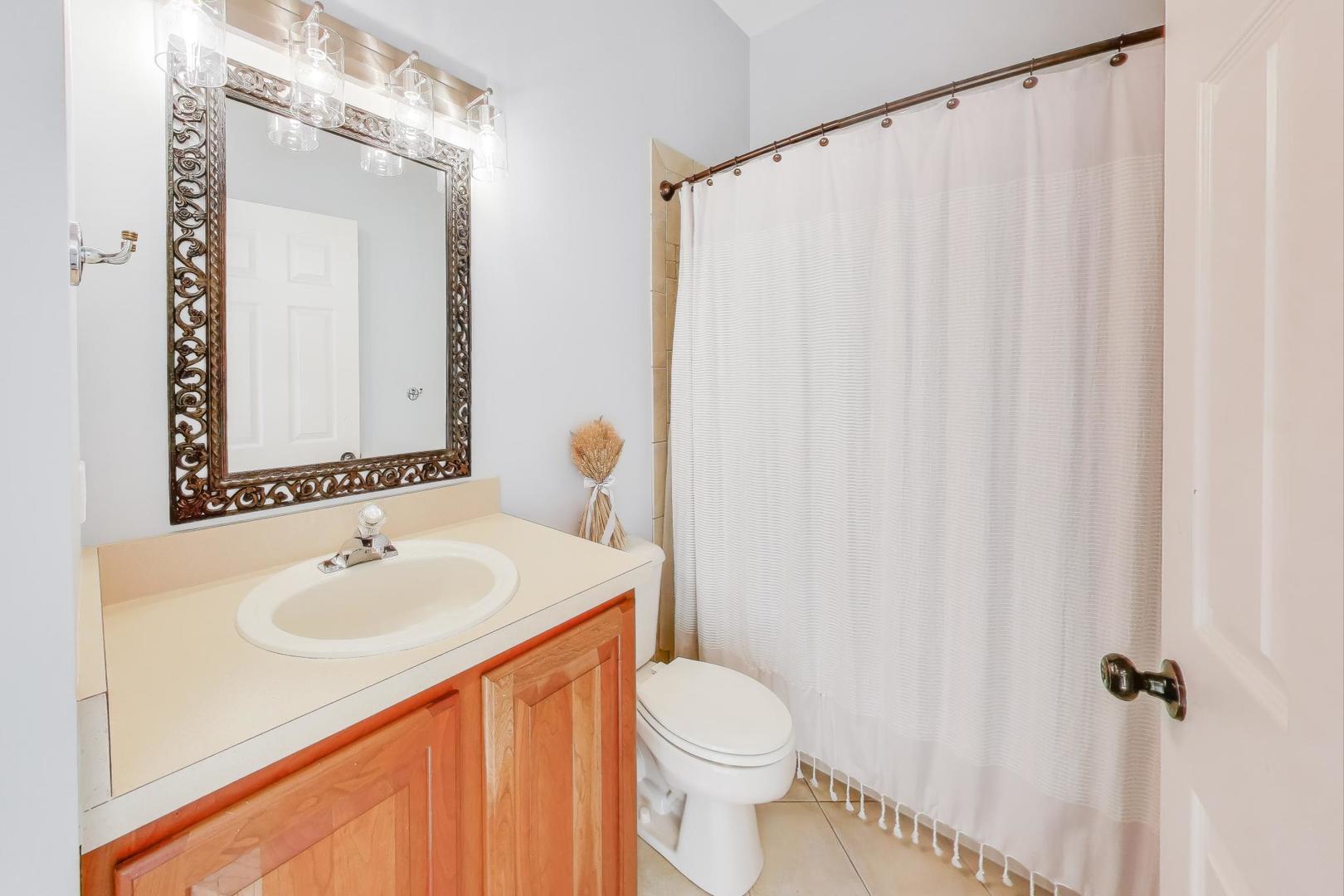2304 Stonegate Road Algonquin, IL 60102 - Photo 26 of 42 a bathroom with a sink a toilet and shower curtain