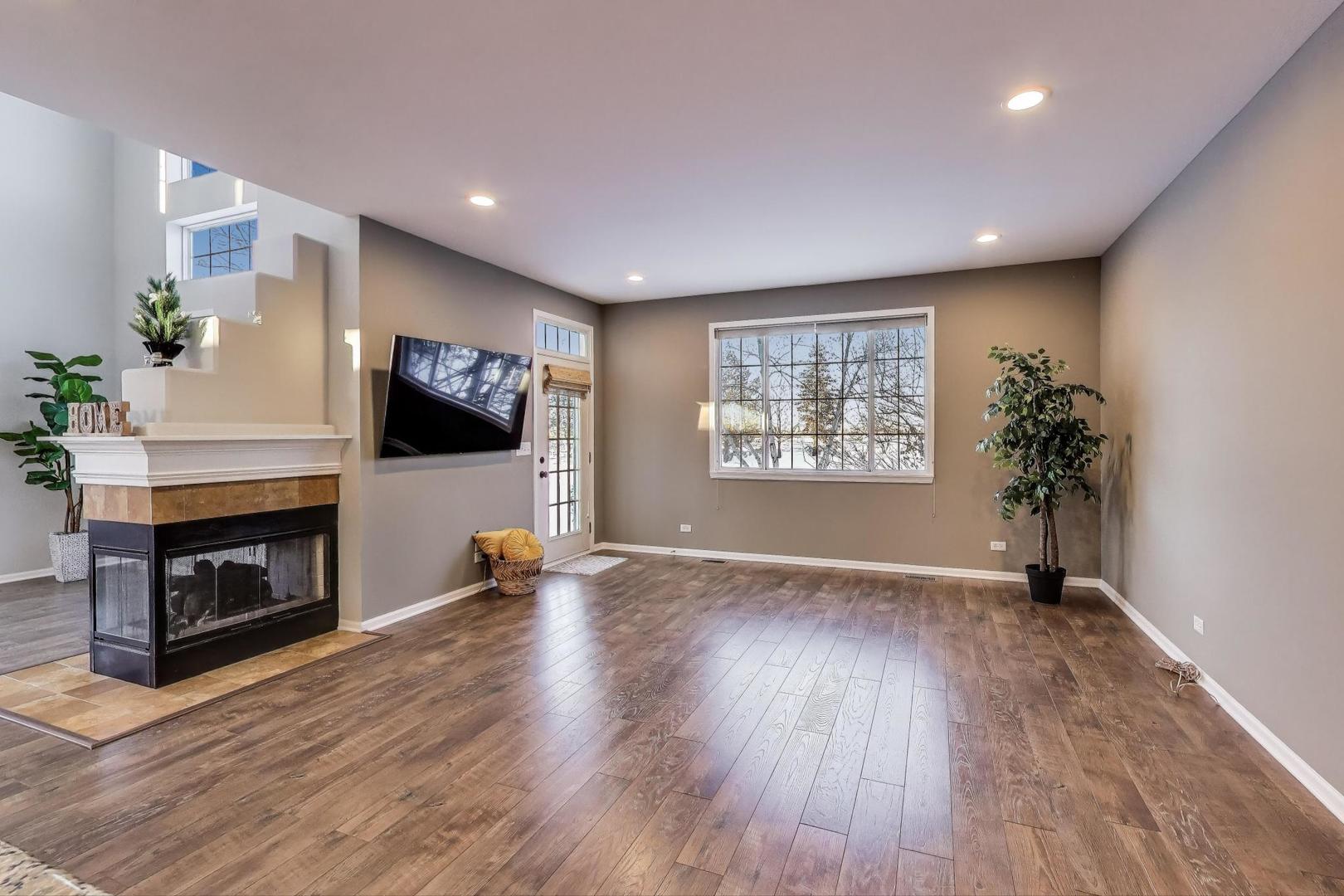2304 Stonegate Road Algonquin, IL 60102 - Photo 7 of 42 a view of an empty room with a fireplace and wooden floor